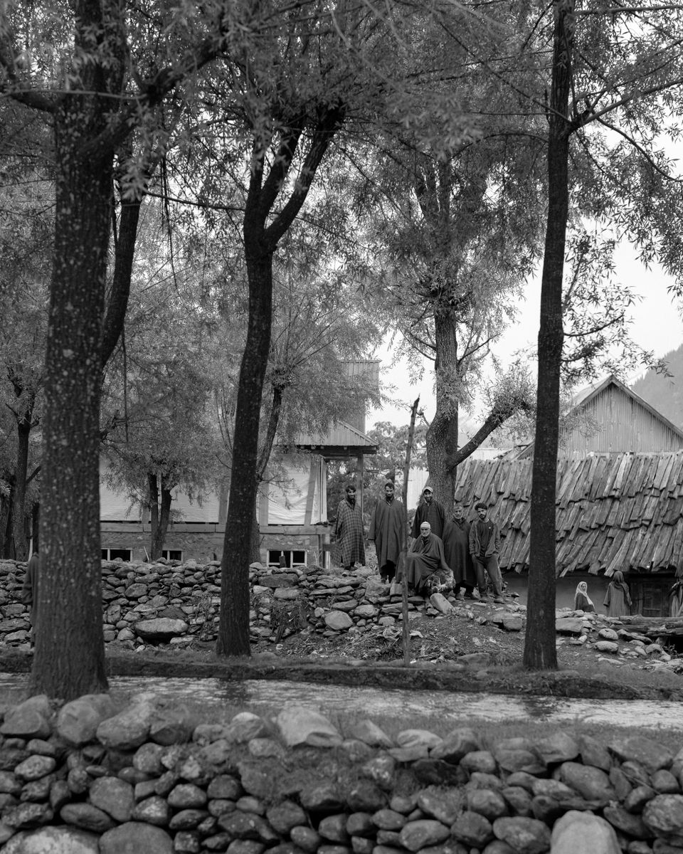 Residents gathered outdoors beneath trees in an Indian village