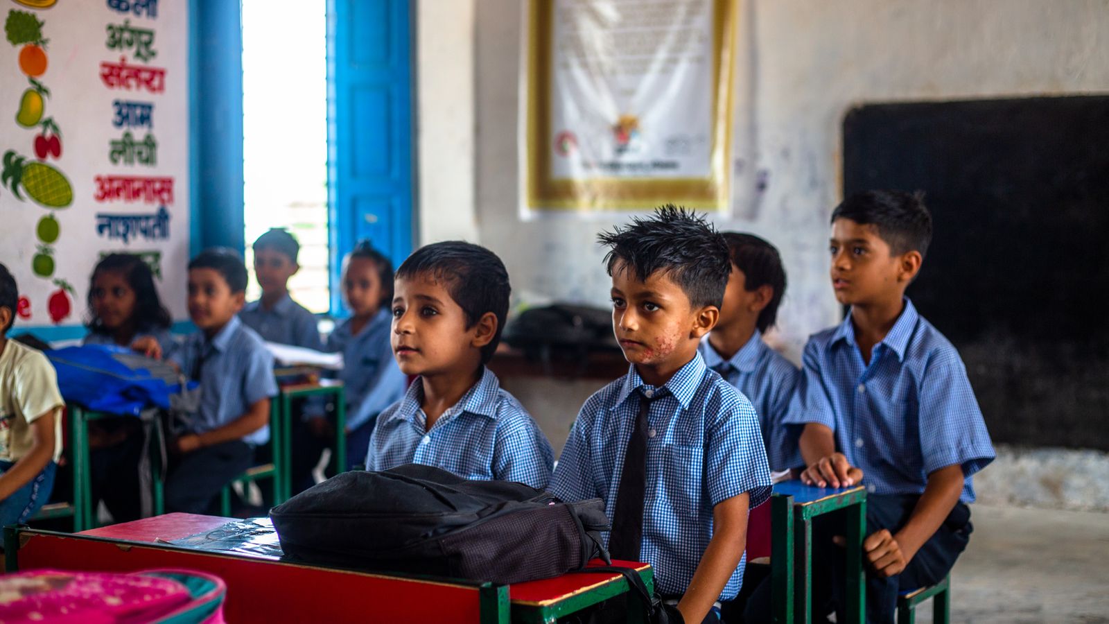 Schoolchildren in uniform listening together in an Indian classroom